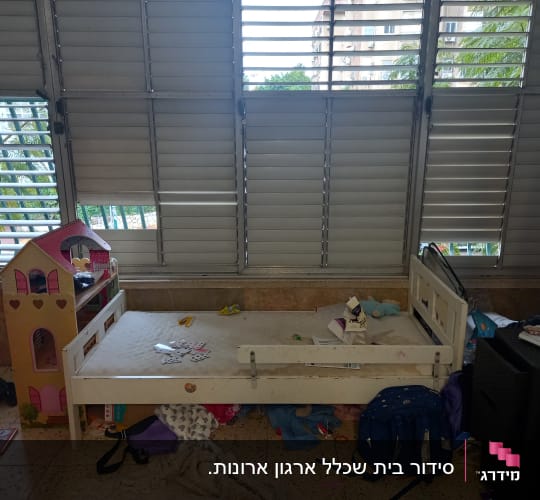 חדר ילדים מבולגן עם מיטה ובית בובות